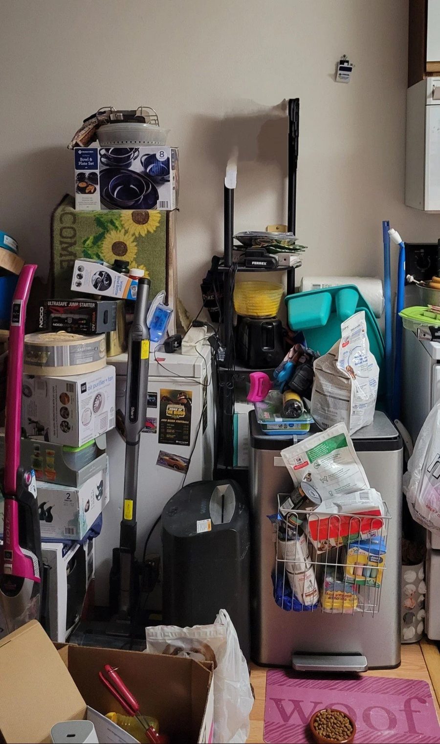 Before: a kitchen corner blocked shoulder-high with stacked boxes and appliances