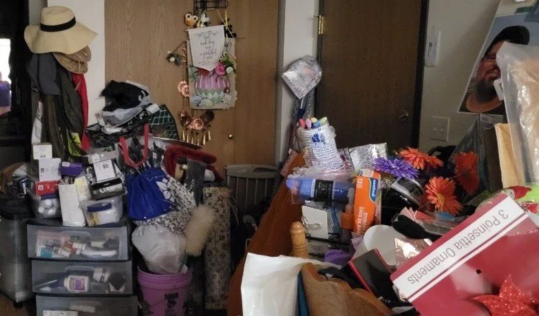 Before: a room with clutter stacked waist-high across the floor and every surface