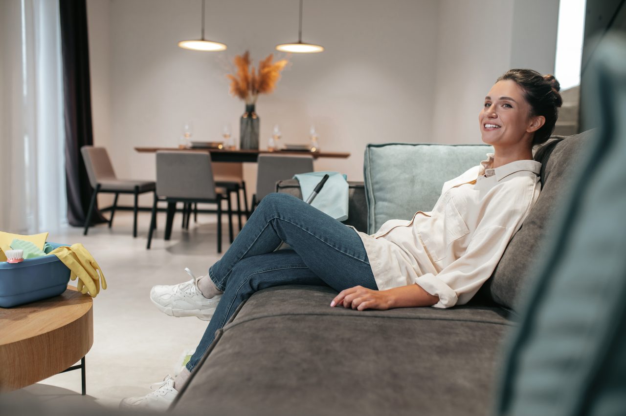 Woman relaxing peacefully on a sofa in a calm, uncluttered living room