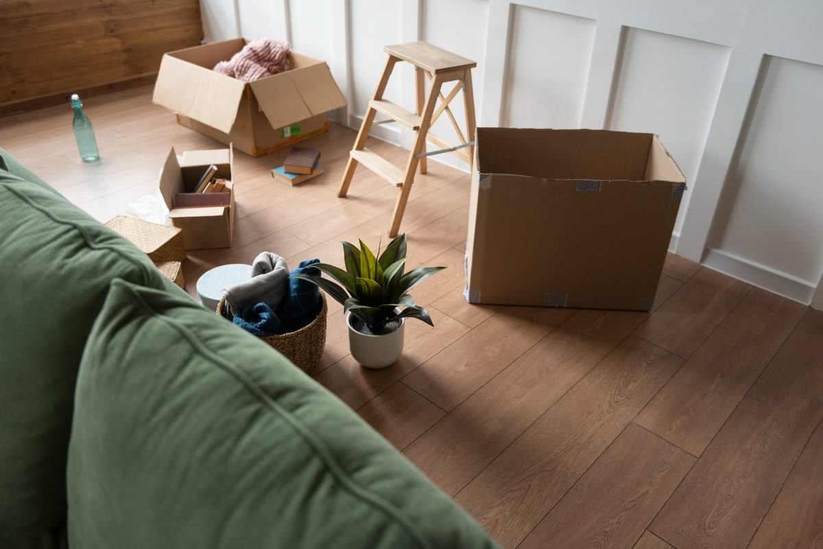 Living room mid-declutter, with sorting boxes and a clear path across the floor