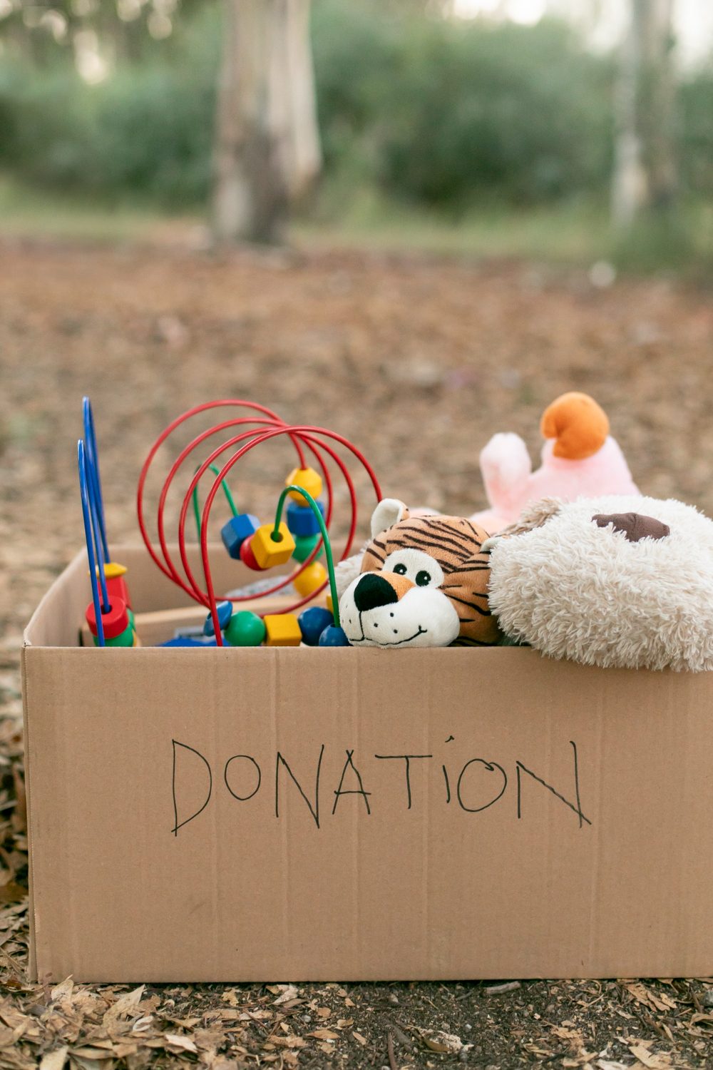 Cardboard box marked DONATION filled with sorted toys, ready for drop-off