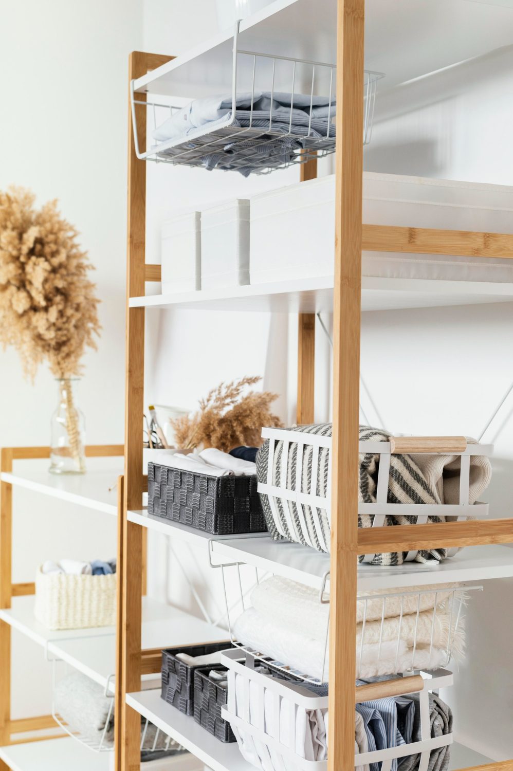Open shelving with folded linens sorted into labelled baskets and bins